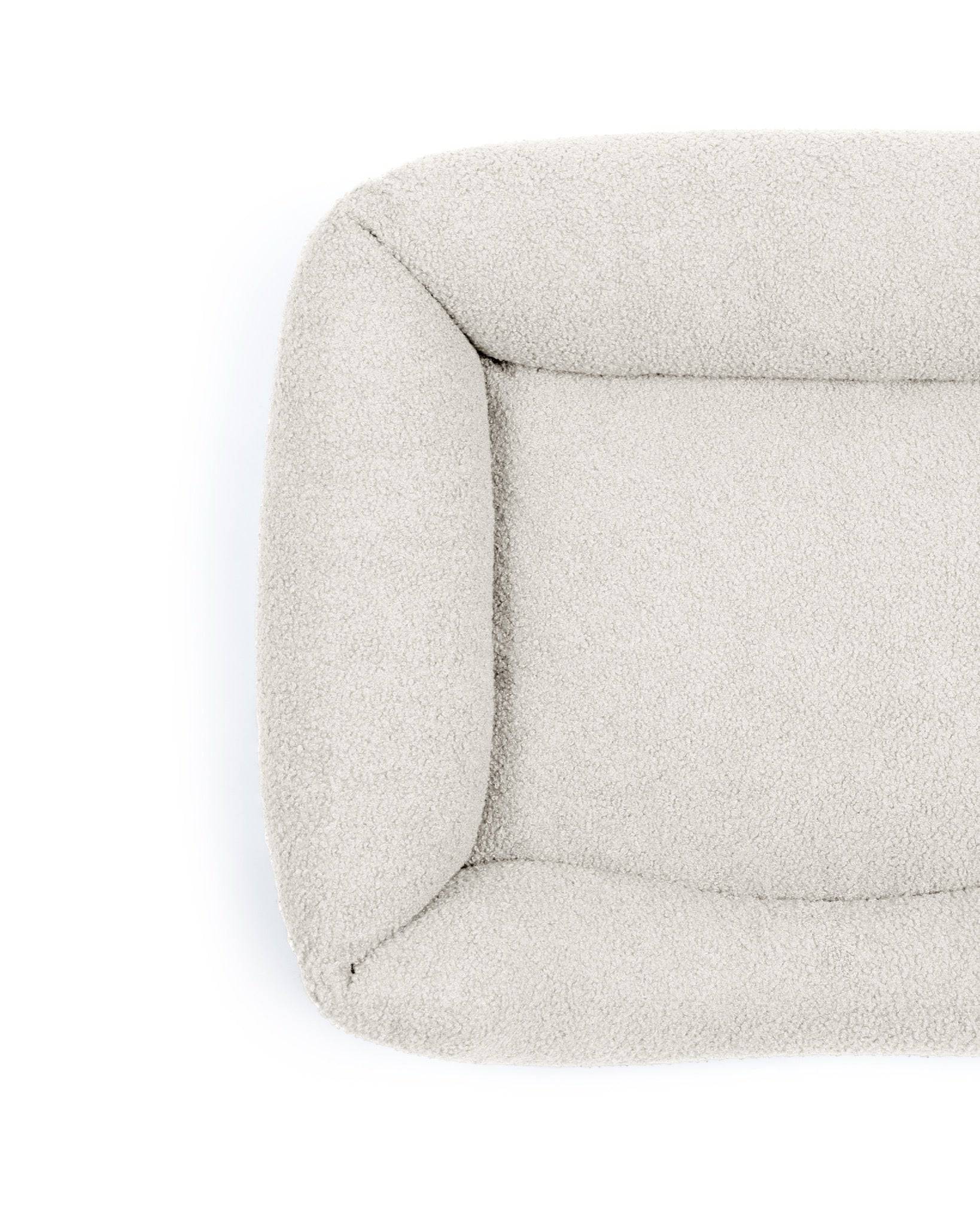 Pet Bouclé Lounge Bed by The Dogs Company in stone color, featuring a cozy, cushioned design for comfortable pet relaxation.