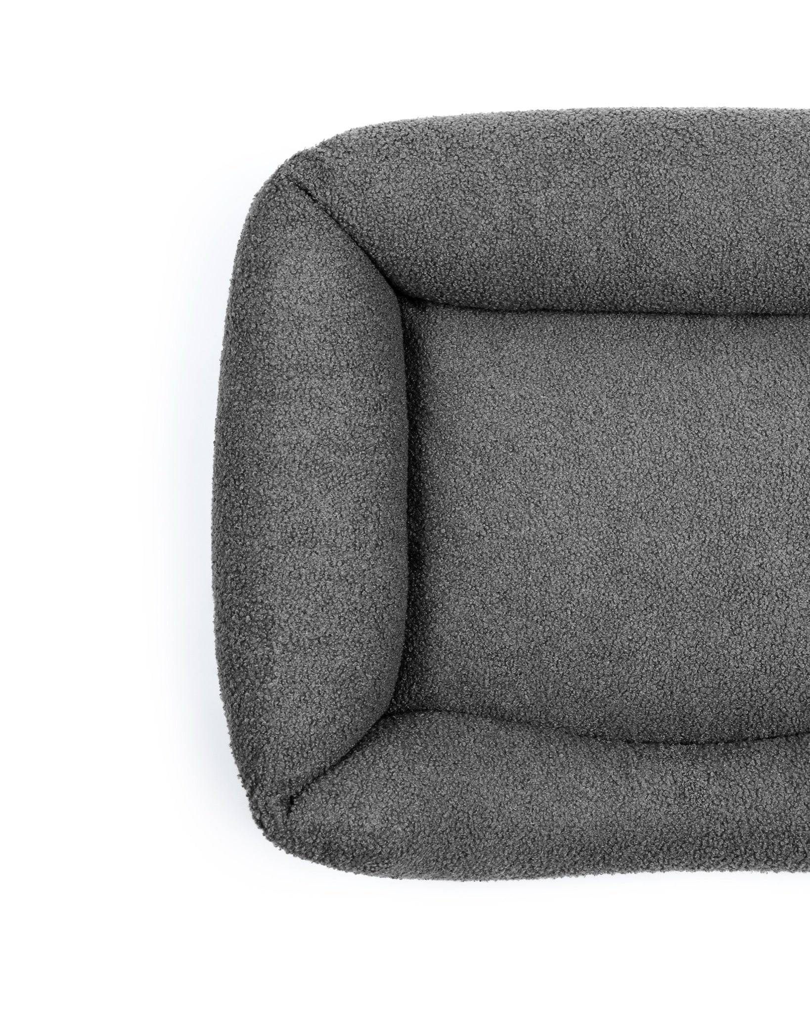 Obsidian bouclé lounge pet bed by The Dogs Company with soft, textured fabric and cozy design for dogs.