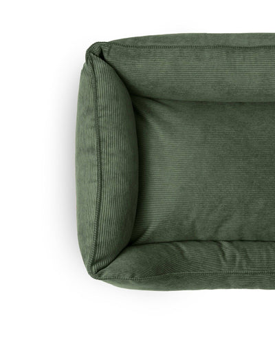 Forest green Ridge Lounge Pet Bed by The Dogs Company, featuring plush cushioning and a cozy, raised edge design for comfort.